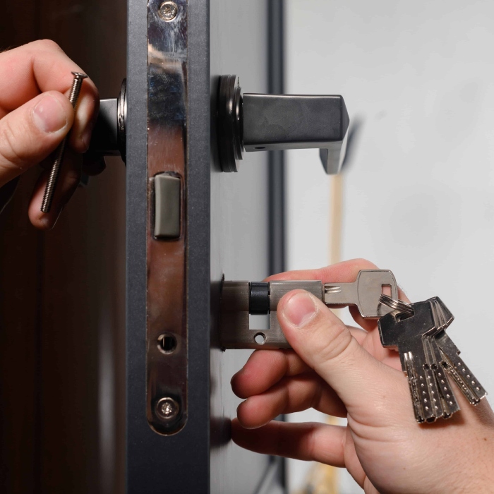 Locksmith installing a high-security lock cylinder on a residential door